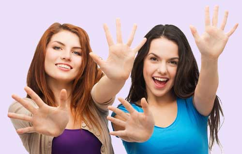 two smiling girls showing their palms